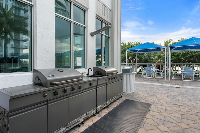 view of patio with outdoor dining space, area for grilling, and an outdoor kitchen