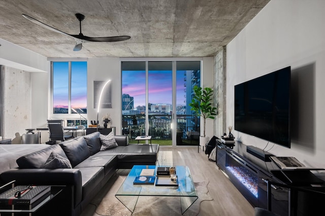 living area with wood finished floors, a ceiling fan, and floor to ceiling windows