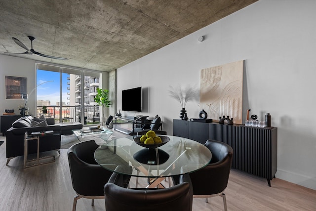 dining room with floor to ceiling windows, ceiling fan, baseboards, and wood finished floors