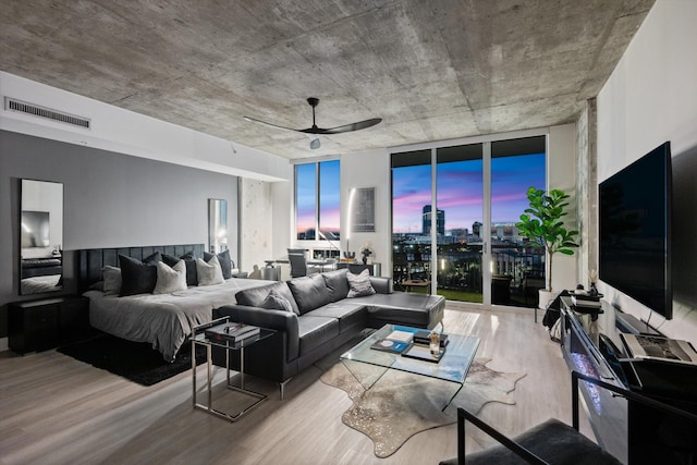 bedroom featuring visible vents, ceiling fan, wood finished floors, access to exterior, and floor to ceiling windows