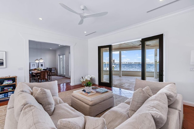 tiled living area with baseboards, a water view, and crown molding