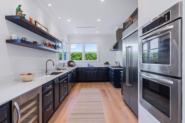 kitchen featuring open shelves, light countertops, appliances with stainless steel finishes, a sink, and beverage cooler