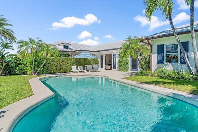 view of swimming pool with a fenced in pool, a yard, and a patio