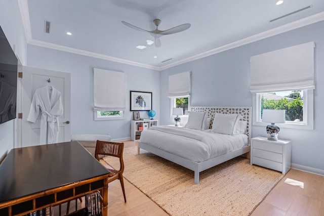 bedroom with ornamental molding, visible vents, and light wood finished floors