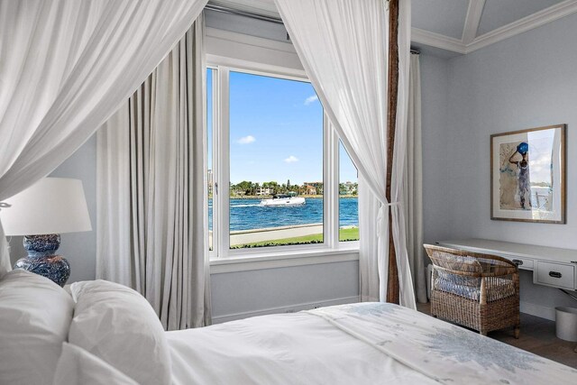 bedroom with ornamental molding, a water view, wood finished floors, and built in study area