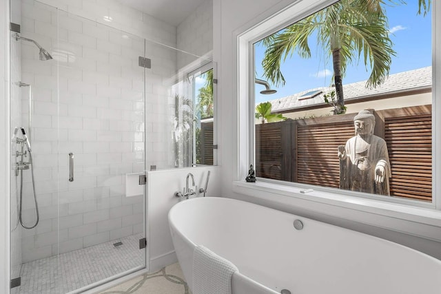 full bath featuring a freestanding tub and a shower stall