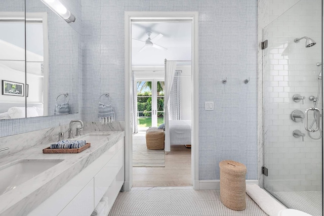 bathroom with a sink, double vanity, a stall shower, and connected bathroom