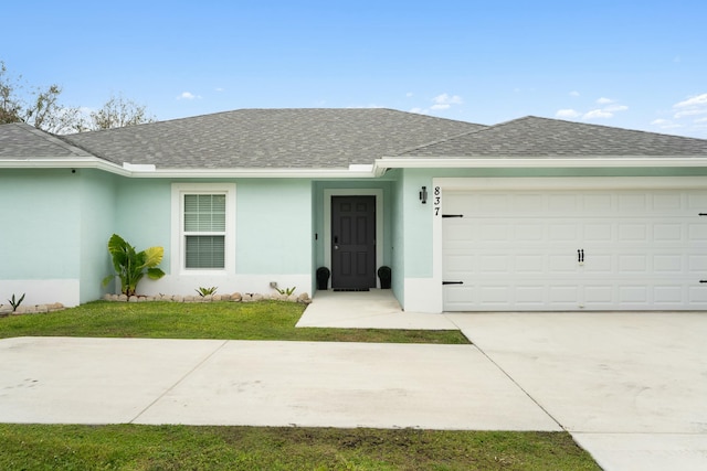 ranch-style home featuring driveway, stucco siding, a garage, and roof with shingles