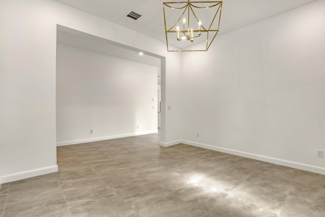 spare room with baseboards, visible vents, and a chandelier