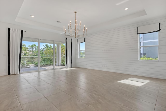 unfurnished room featuring a tray ceiling, recessed lighting, visible vents, and an inviting chandelier