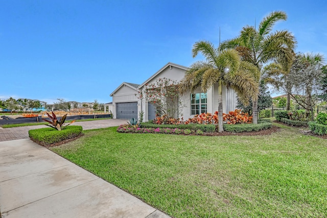 single story home featuring driveway, an attached garage, and a front yard