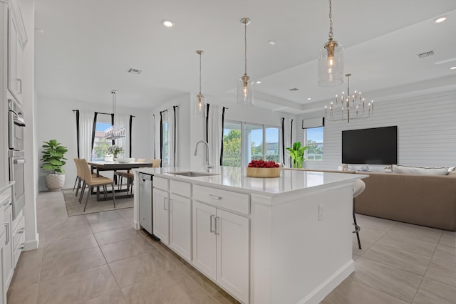 kitchen featuring a center island with sink, visible vents, white cabinets, open floor plan, and light countertops