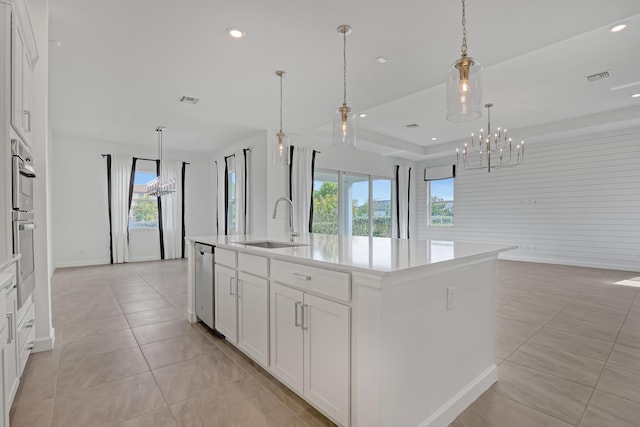 kitchen featuring visible vents, white cabinetry, open floor plan, light countertops, and an island with sink