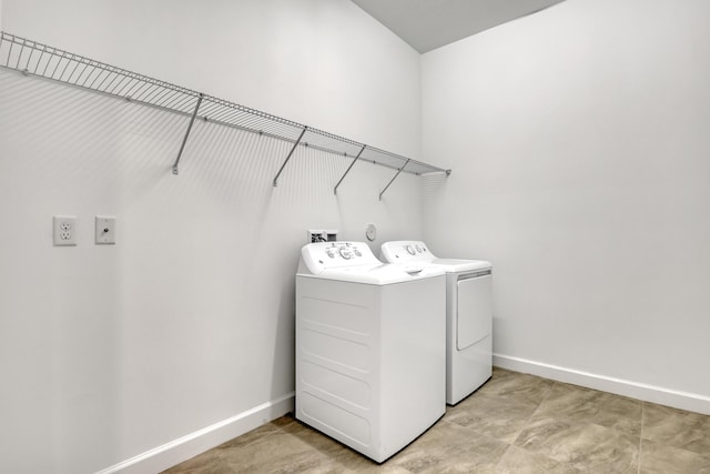 laundry room with laundry area, separate washer and dryer, and baseboards