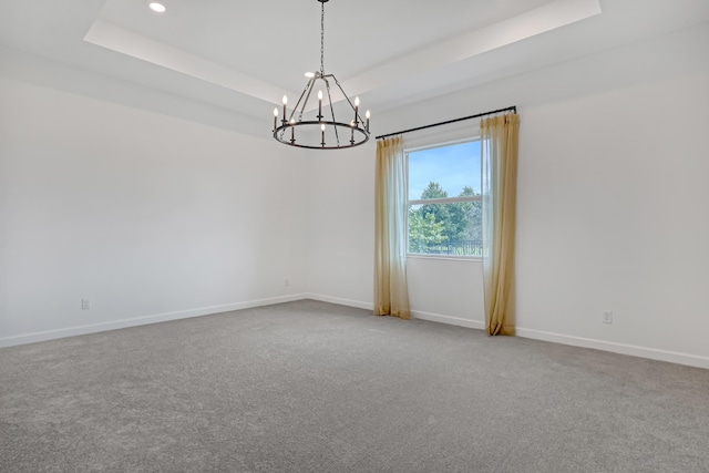 carpeted spare room featuring a tray ceiling, an inviting chandelier, baseboards, and recessed lighting