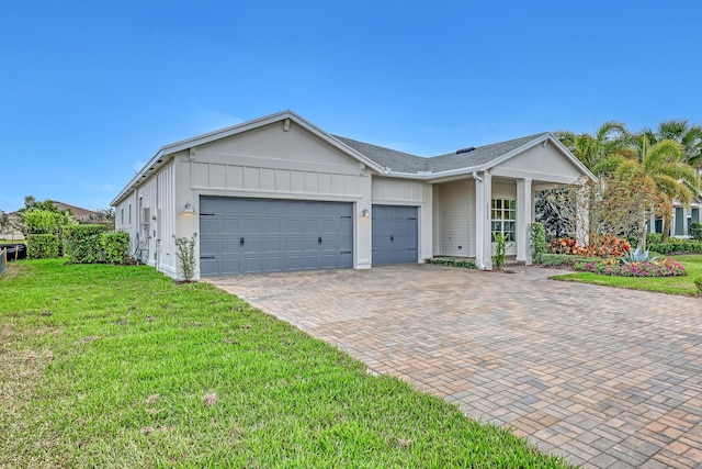 ranch-style house with a front lawn, decorative driveway, an attached garage, and board and batten siding