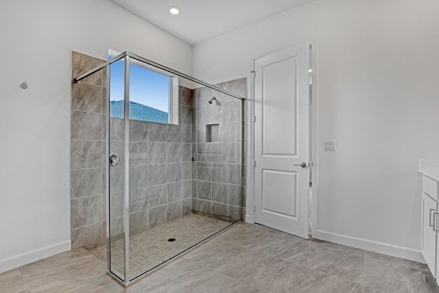 full bathroom with a stall shower, vanity, and baseboards