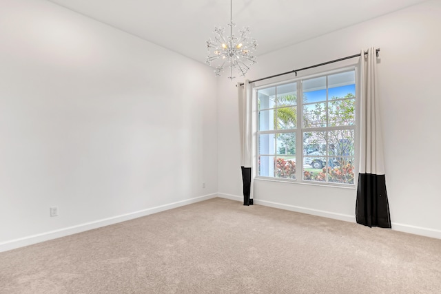 carpeted spare room featuring a chandelier and baseboards