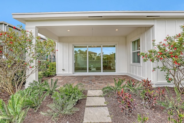 rear view of property featuring board and batten siding and a patio area