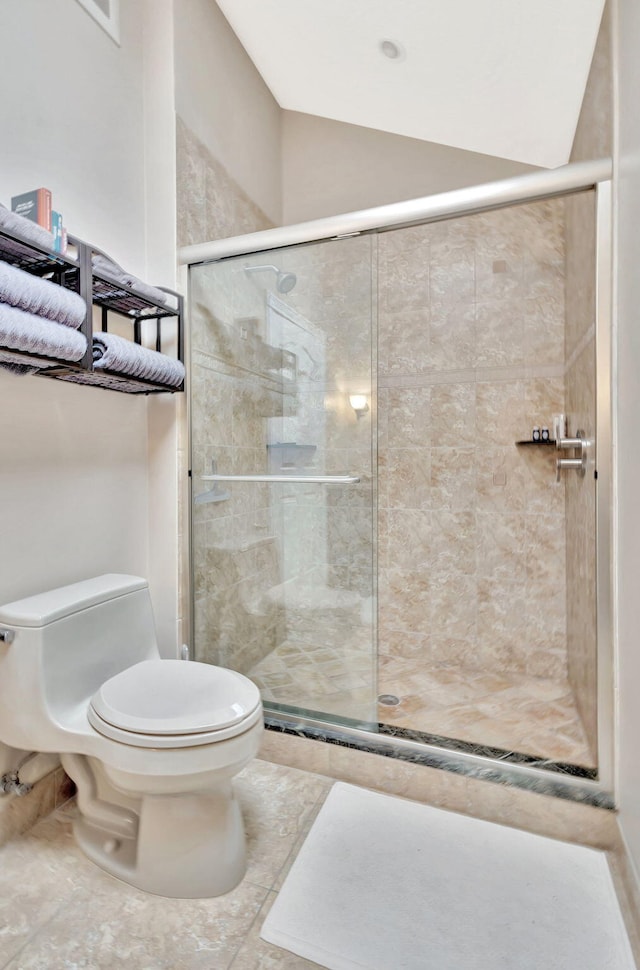 full bath with vaulted ceiling, a shower stall, and toilet