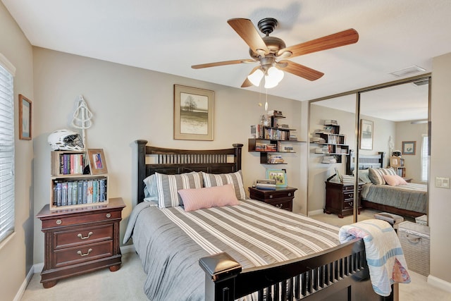 bedroom featuring light carpet, ceiling fan, a closet, and baseboards