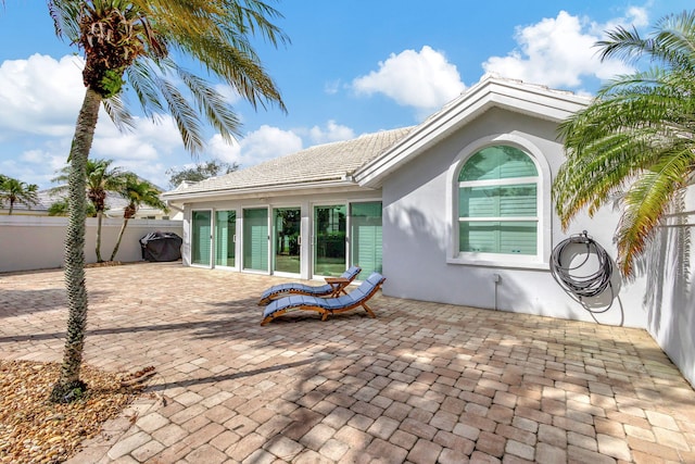 back of house featuring a patio, fence, and stucco siding