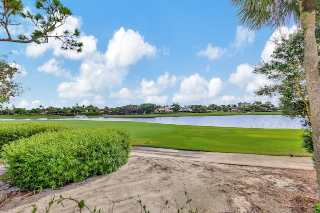 view of community with a yard, golf course view, and a water view