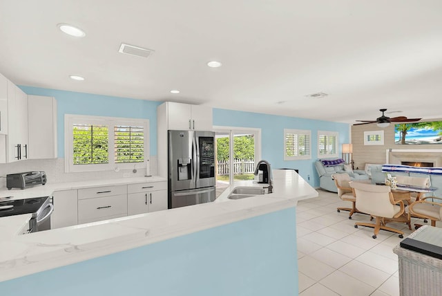 kitchen featuring a sink, visible vents, white cabinetry, appliances with stainless steel finishes, and backsplash