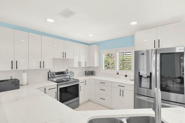 kitchen featuring stainless steel appliances, white cabinets, light stone counters, and modern cabinets