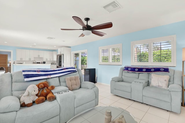 living room featuring a ceiling fan, visible vents, baseboards, and light tile patterned flooring