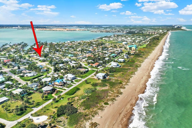 birds eye view of property with a water view and a beach view