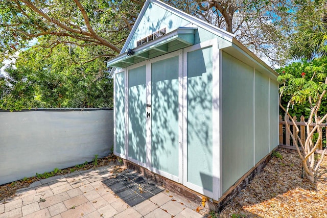 view of shed featuring fence