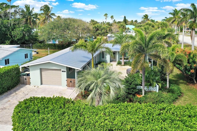 view of front of house featuring driveway, a garage, fence, and stucco siding