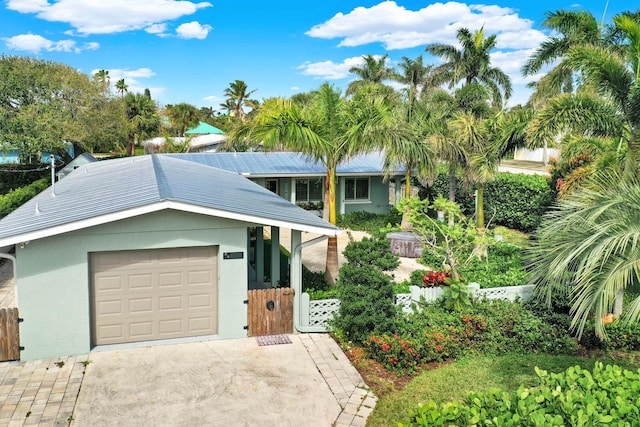 view of front of property featuring driveway, fence, an attached garage, and stucco siding