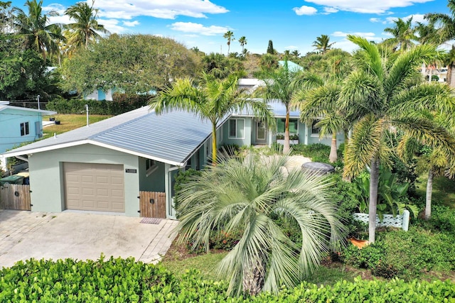 view of front facade with a garage, concrete driveway, and stucco siding