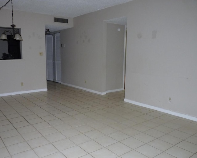 spare room with visible vents, a textured ceiling, and baseboards