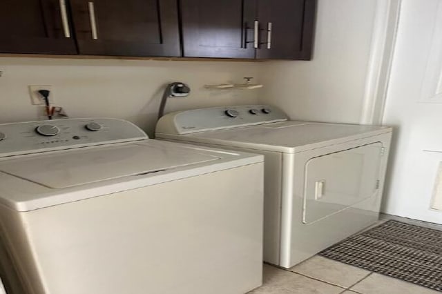 laundry room featuring cabinet space, washing machine and dryer, and light tile patterned floors