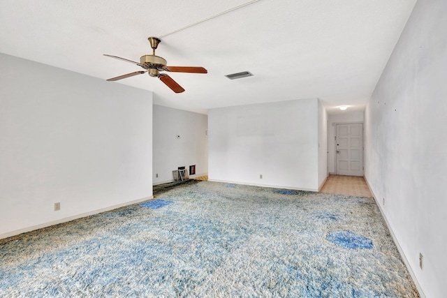 unfurnished room featuring light carpet, baseboards, visible vents, and a ceiling fan