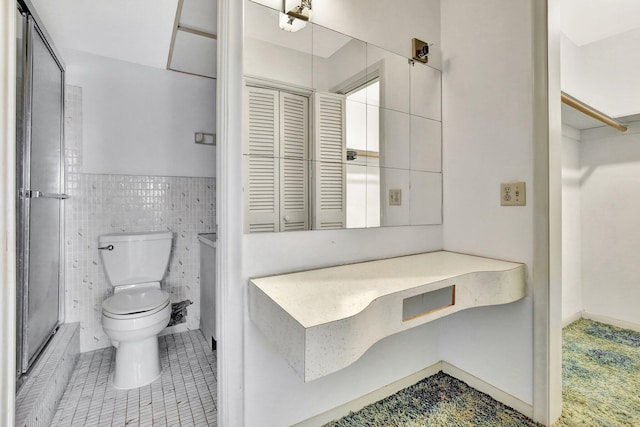 full bath featuring toilet, tile walls, a closet, and tile patterned floors