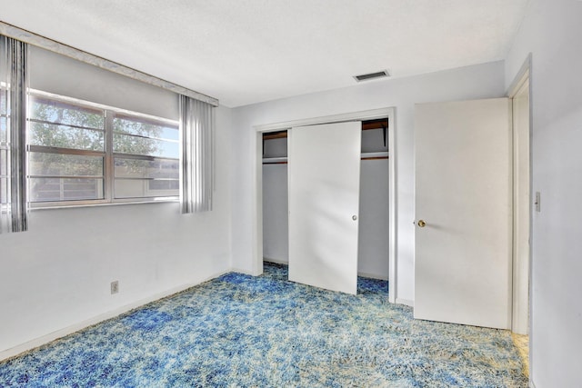 unfurnished bedroom with a closet, visible vents, baseboards, and carpet flooring