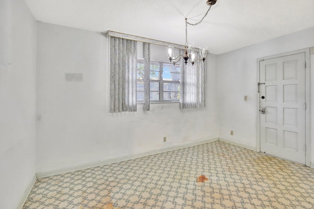 unfurnished dining area with a notable chandelier and baseboards