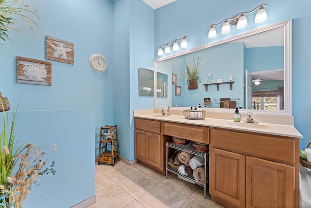 full bath with double vanity, tile patterned flooring, and a sink