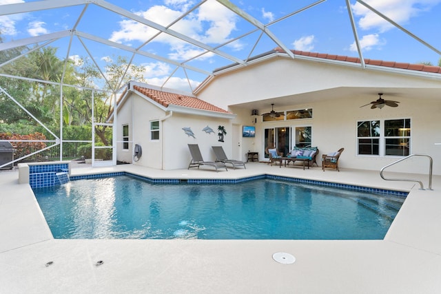 outdoor pool featuring glass enclosure, a patio area, and a ceiling fan