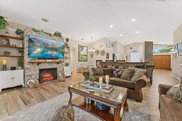 living room featuring visible vents, lofted ceiling, light wood-style flooring, a fireplace, and recessed lighting