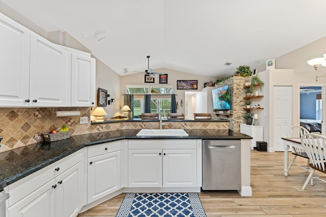 kitchen with a peninsula, white cabinets, and a sink