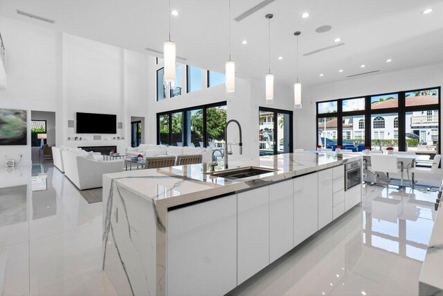 kitchen featuring modern cabinets, white cabinetry, pendant lighting, and a sink