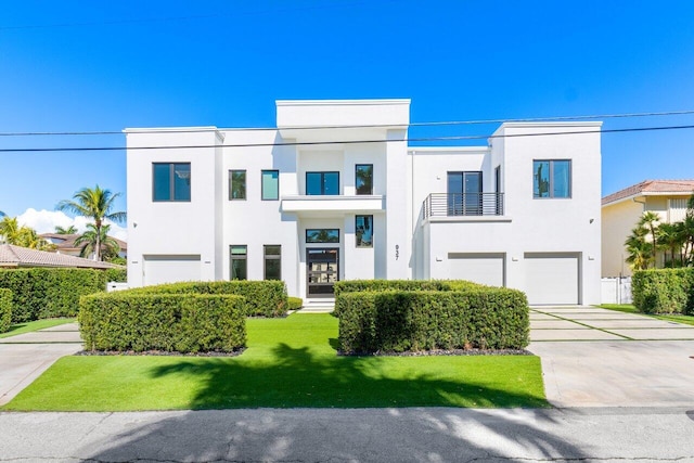 view of front of home with a garage, driveway, a front lawn, and stucco siding