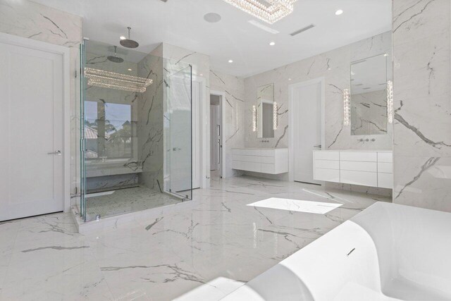 full bath with marble finish floor, a marble finish shower, recessed lighting, a freestanding tub, and stone wall