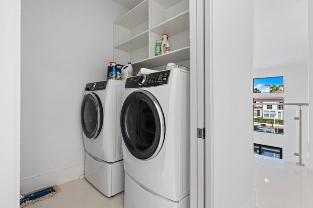 laundry room with light tile patterned floors, cabinet space, washer and clothes dryer, and a sink