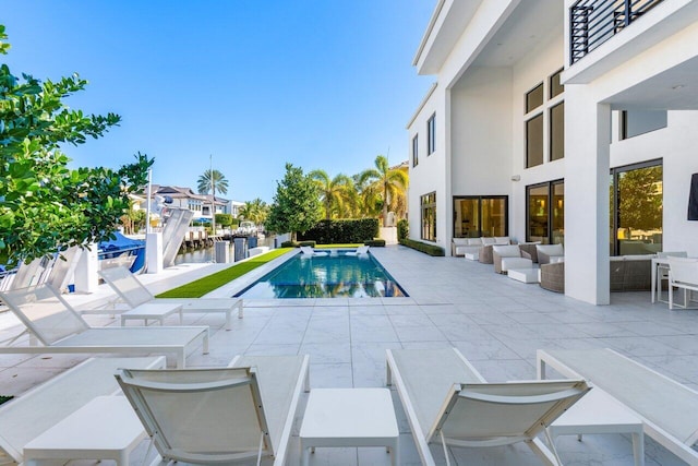 pool featuring a patio area and a water view